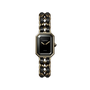 The Chanel Première Édition Originale Medium Model features a black-lacquered dial, yellow gold steel bezel, gold hands, and a chain-link bracelet interwoven with black leather.