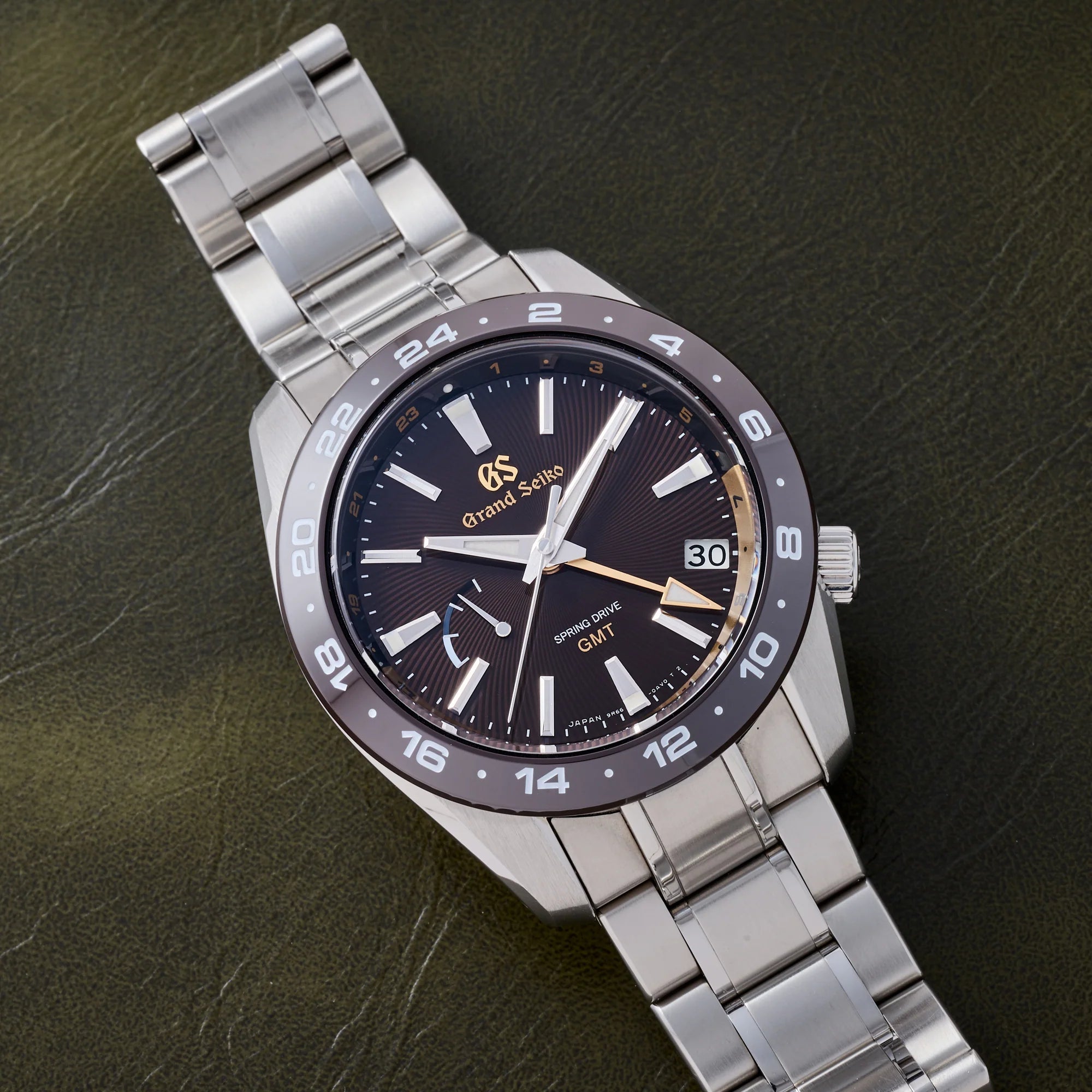 Silver wristwatch with a dark face on a textured dark background