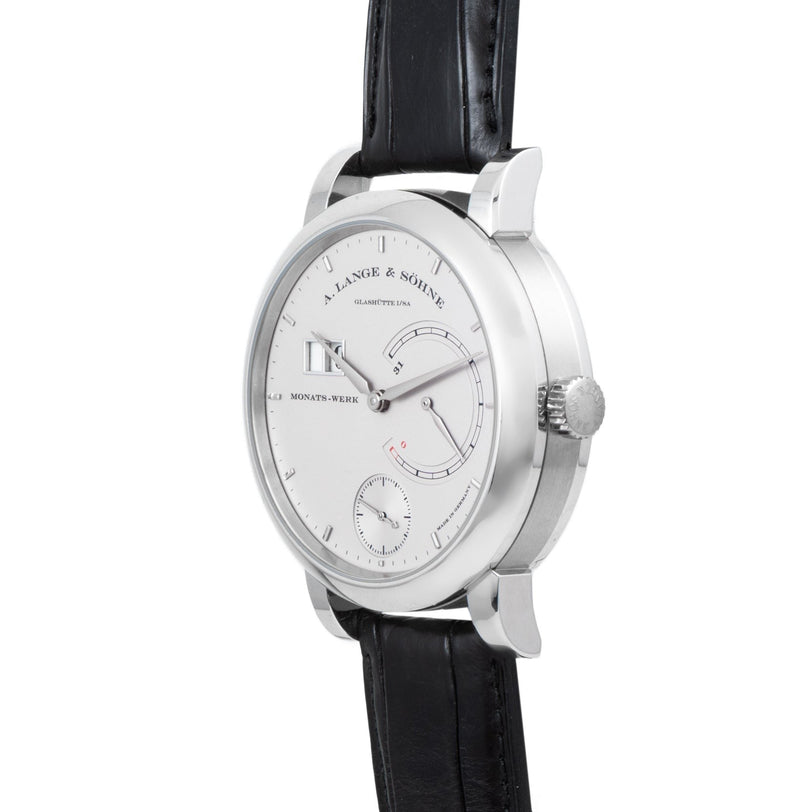 The Lange & Sohne Lange 31 is a silver wristwatch with a black leather strap, featuring a white dial and small subdials.