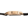 Side view of the Lange & Sohne Lange 1 Tourbillon gold case with a black leather strap and visible crown.