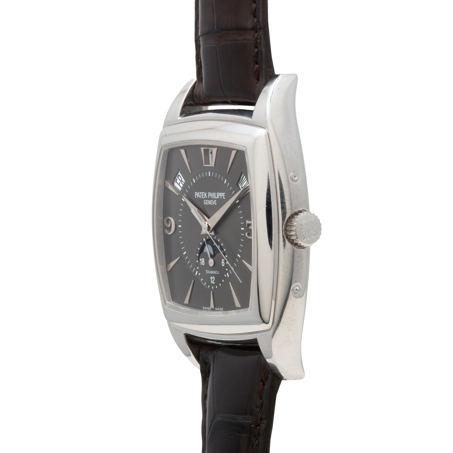 A Patek Philippe Gondolo Annual Calendar wristwatch with a silver case, black dial, and brown leather strap, displayed from a side angle.