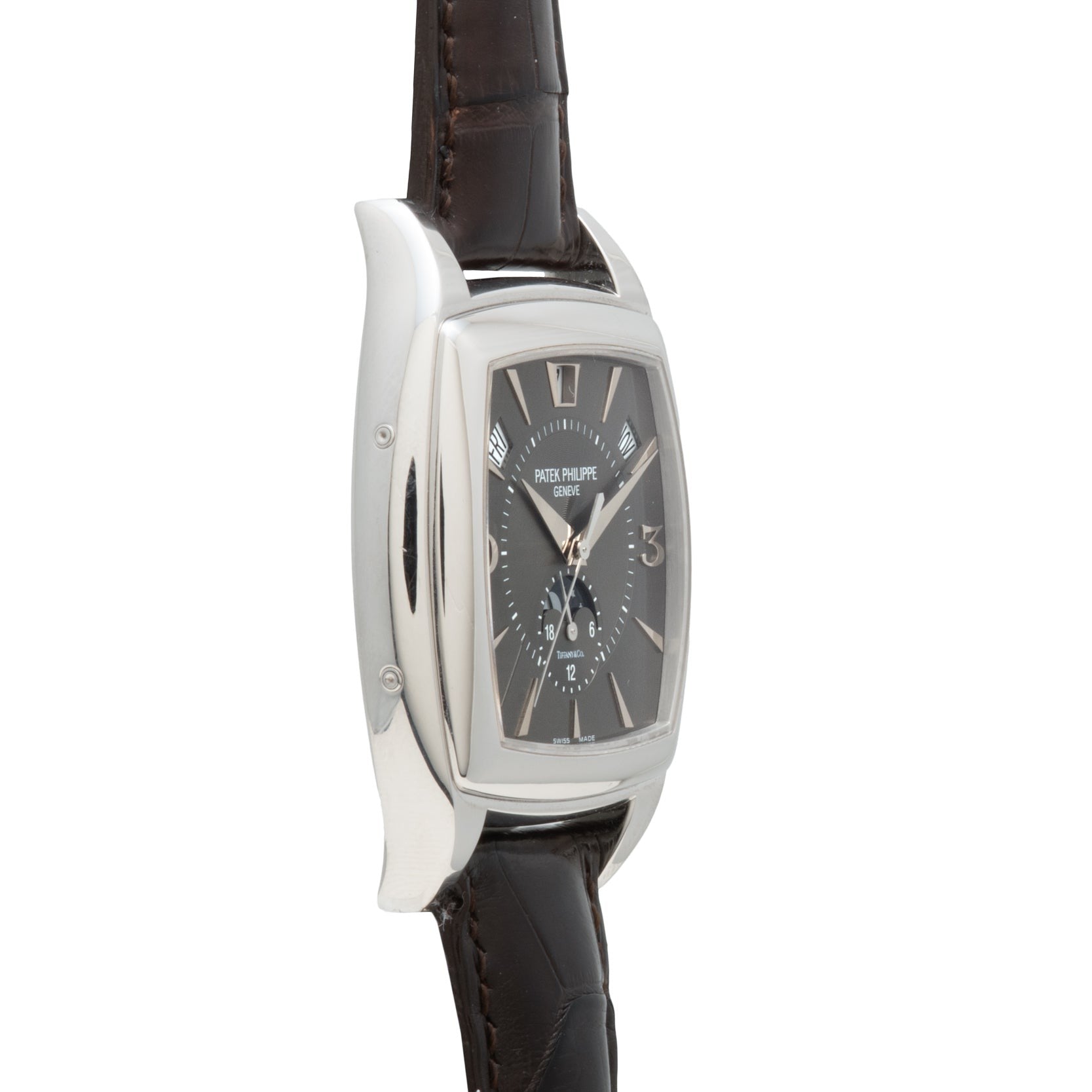 A Patek Philippe Gondolo Annual Calendar wristwatch with a silver case, dark rectangular face, and brown leather strap, viewed from an angle.