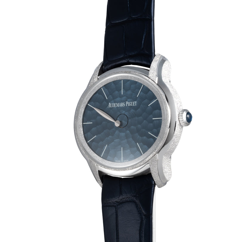 The Audemars Piguet Millenary Philosophique is a luxury watch featuring a blue textured dial and a dark leather strap.