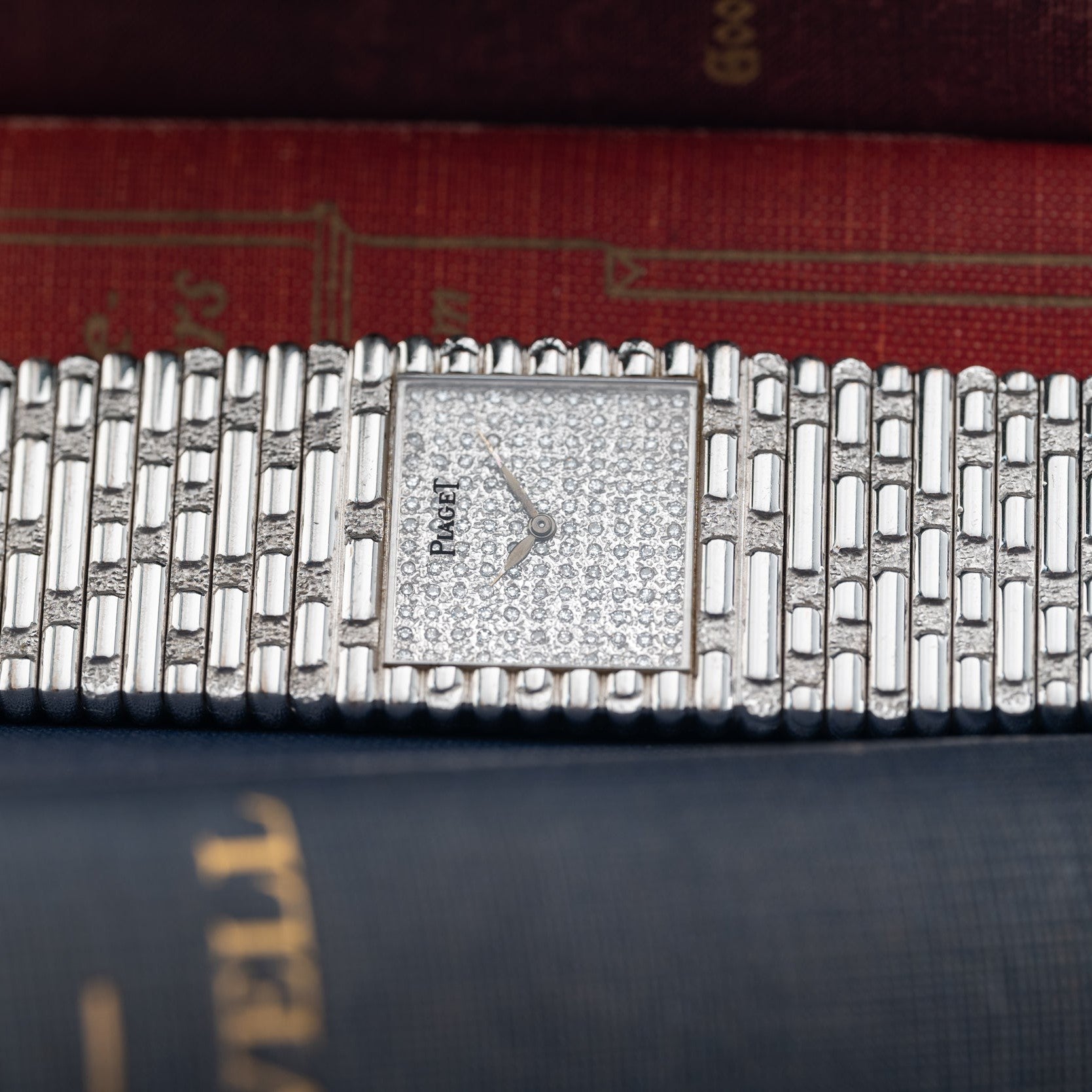 An Emperador Diamond wristwatch by Piaget rests atop a stack of hardcover books.