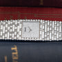 An Emperador Diamond wristwatch by Piaget rests atop a stack of hardcover books.
