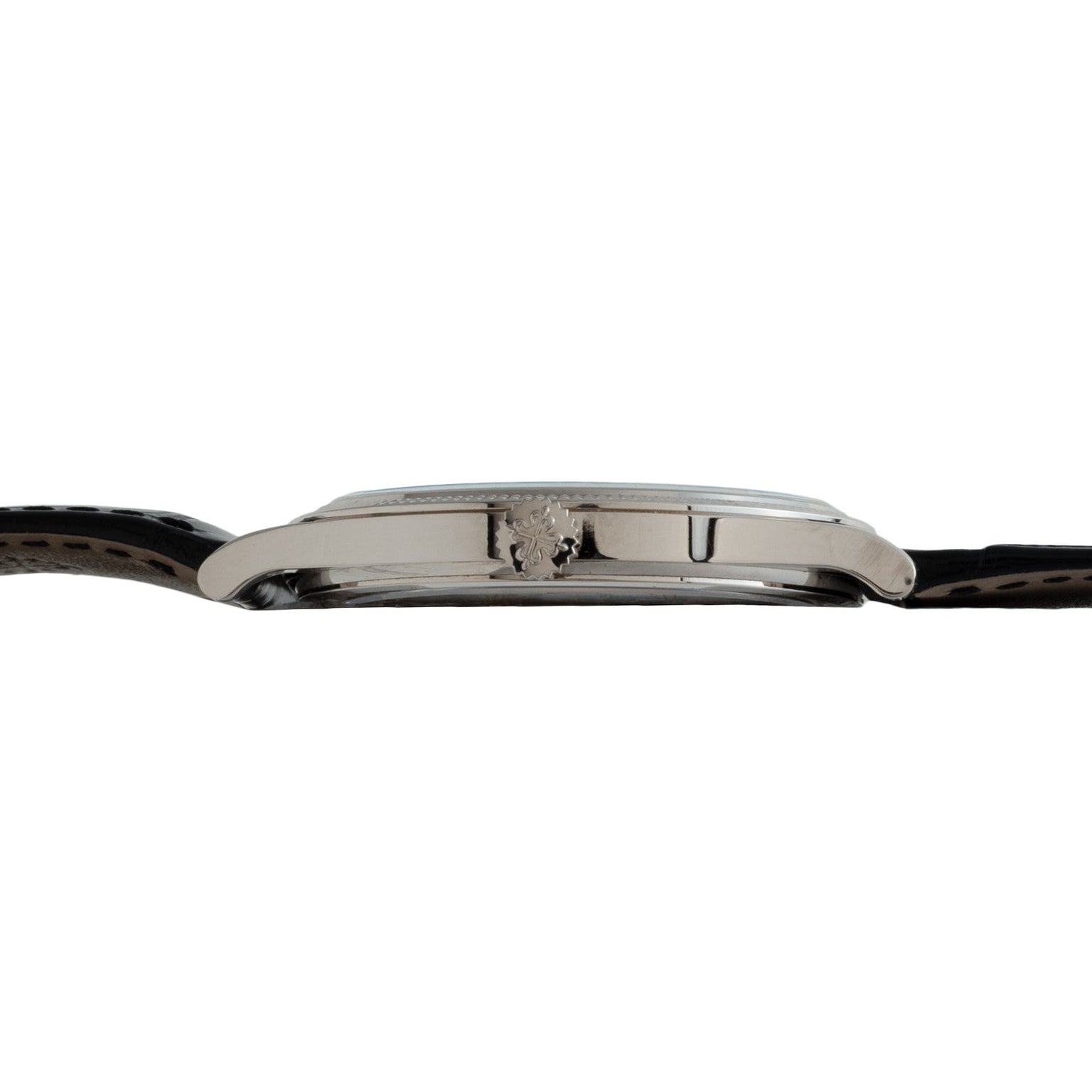Side view of the Patek Philippe Calatrava, a slim wristwatch featuring a black leather strap and a silver crown on the case.
