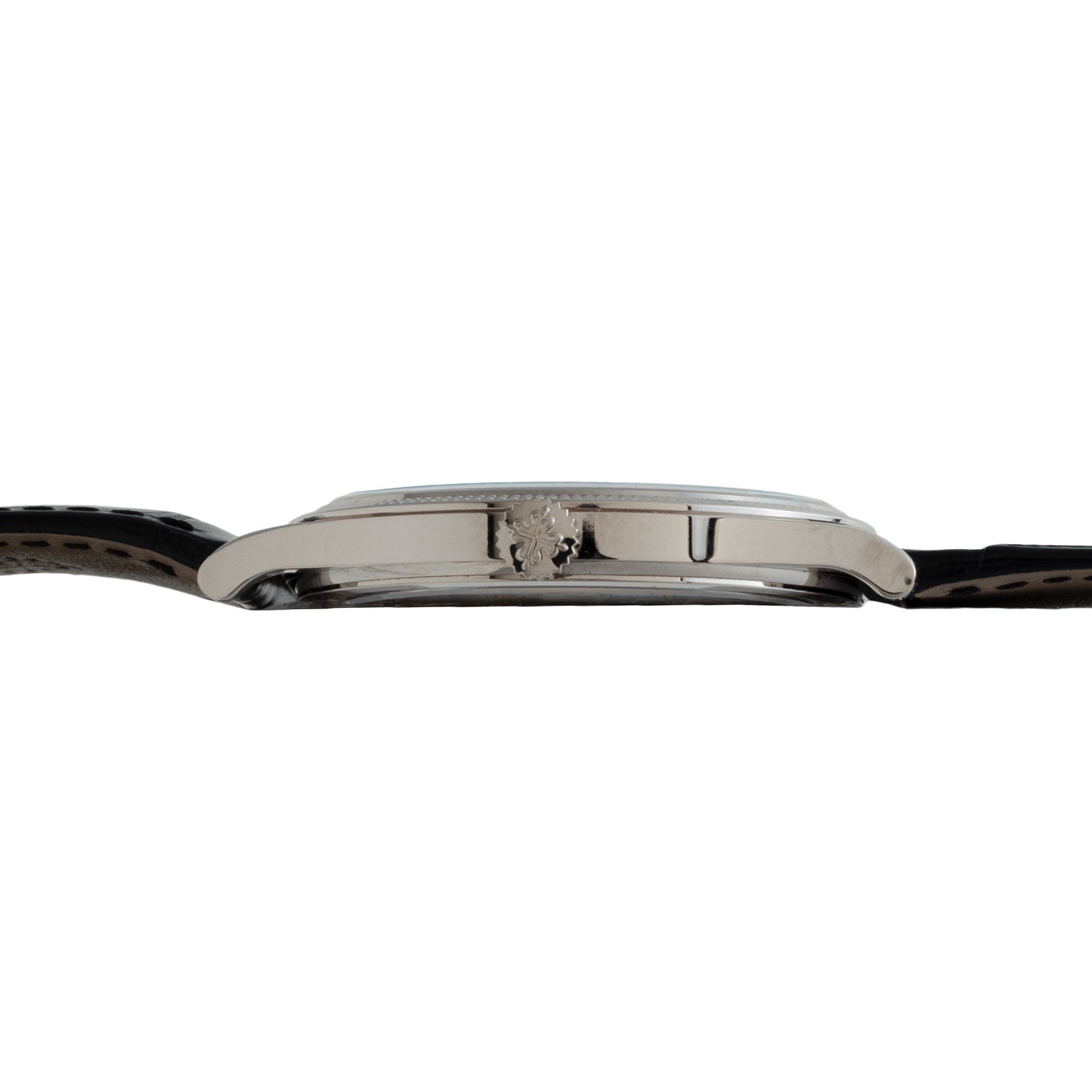 Side view of the Patek Philippe Calatrava, a slim wristwatch featuring a black leather strap and a silver crown on the case.