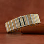 The Piaget Polo Pave, a luxurious gold and silver diamond-encrusted wristwatch, rests on a brown leather surface.