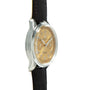 A Breitling Premiere B09 Chronograph 40 gold wristwatch with a black leather strap, shown from a side angle on a white background.