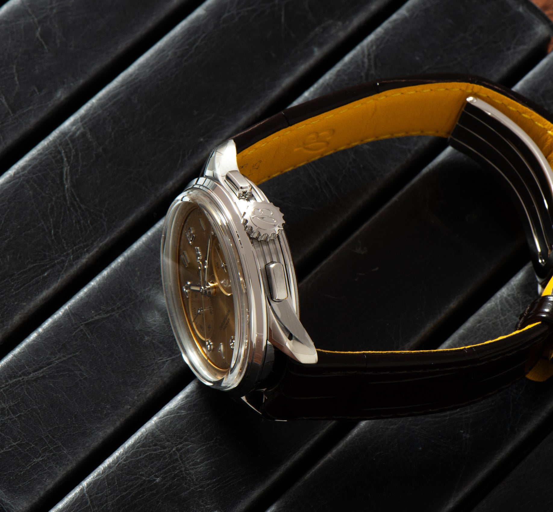 Close-up of the Breitling Premiere B09 Chronograph 40, featuring a brown leather strap and silver casing, displayed on a black textured surface.