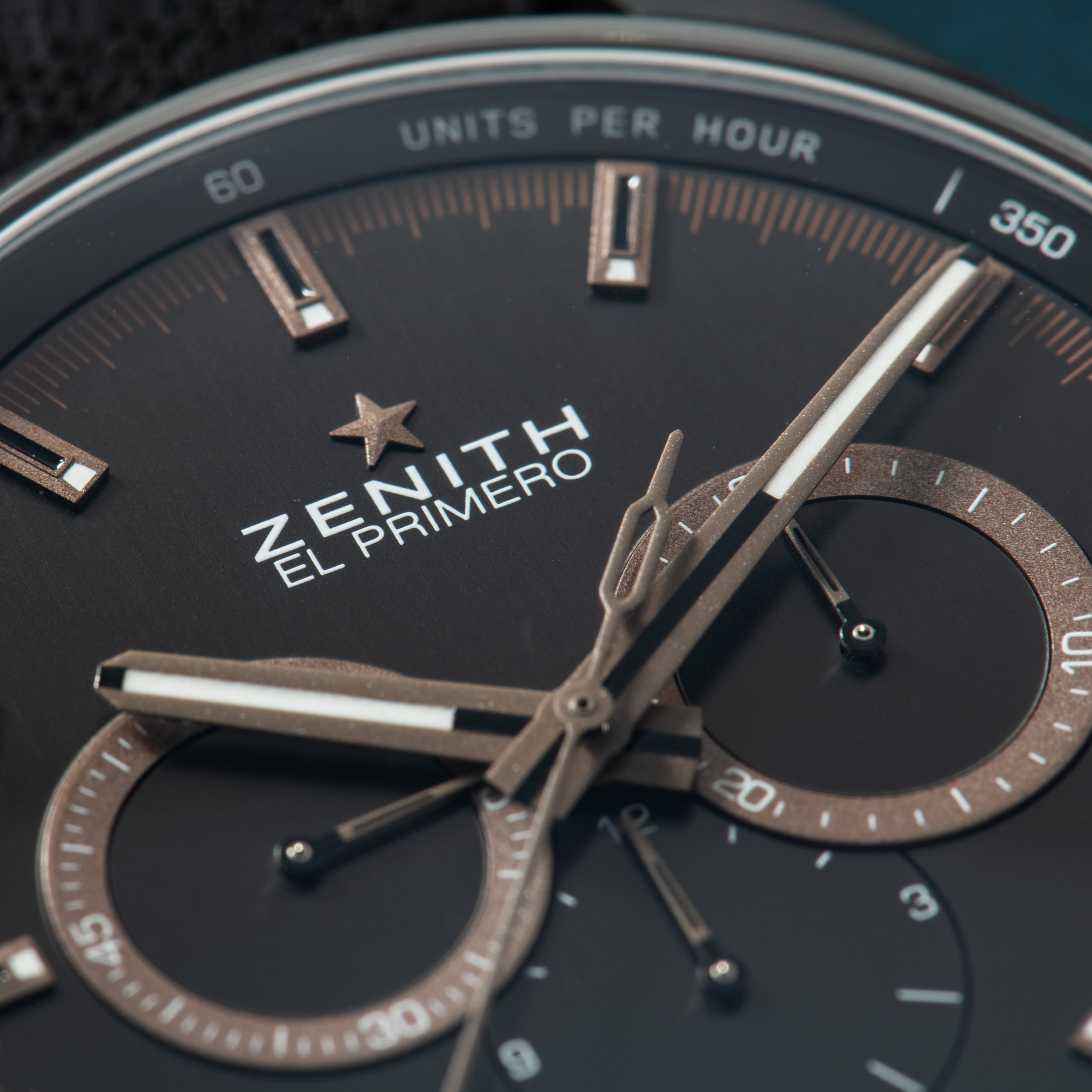 Zenith El Primero chronograph watch with black dial, metallic hands, and dual subdials displaying "Units Per Hour" scale.