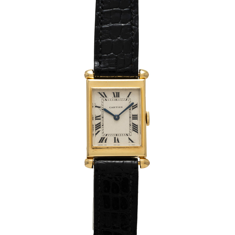 Gold rectangular watch with cream dial, Roman numerals, and black crocodile leather strap.