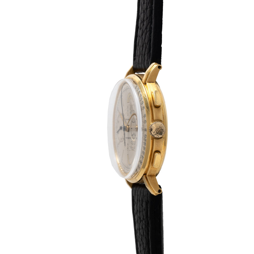 Gold-tone chronograph watch with white dial, tachymeter bezel, and black leather strap.