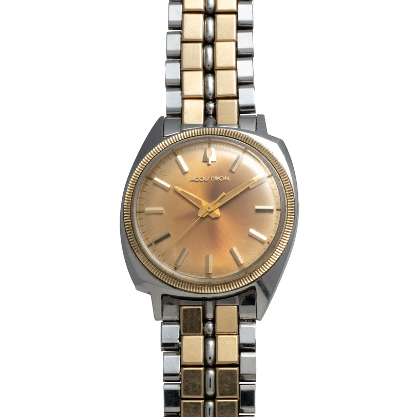 Bulova Accutron watch with two-tone silver and gold case, champagne dial, applied indices, and matching bracelet.
