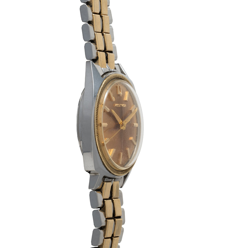 Bulova Accutron watch with oval brown dial, gold-tone hands, two-tone metal and gold bracelet with segmented links.