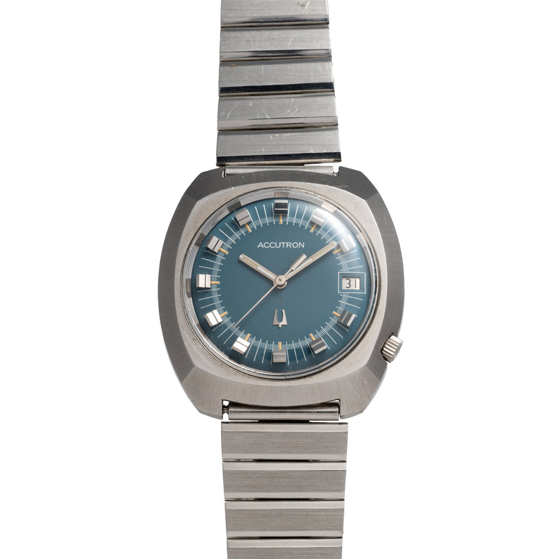 Bulova Accutron 261 cushion-shaped watch with blue dial, silver-tone metal case and bracelet band.