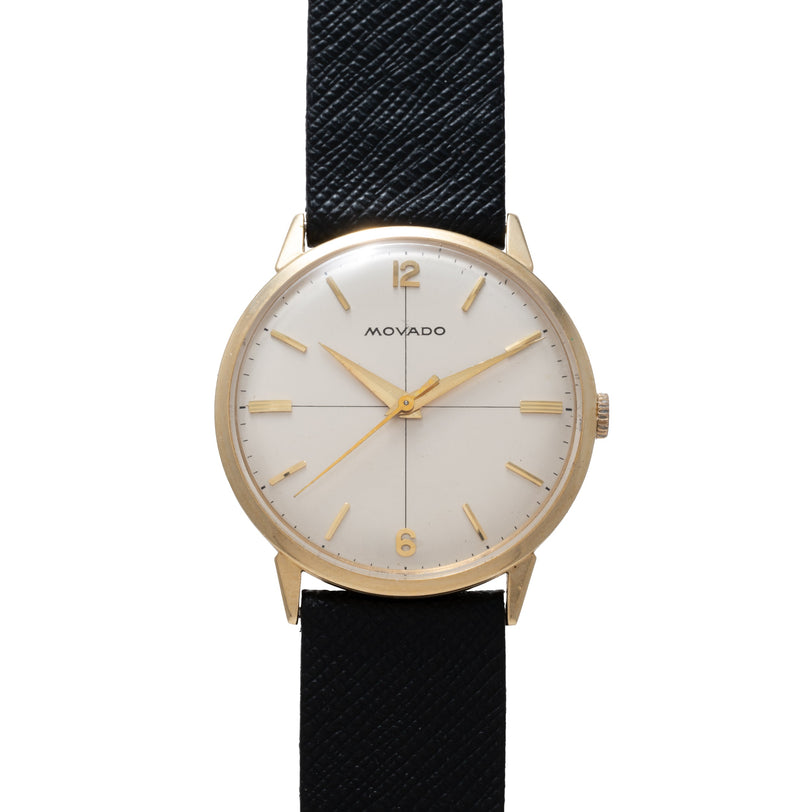 Movado Calatrava watch with gold-tone case, silver dial, gold hour markers and hands, black textured leather strap.