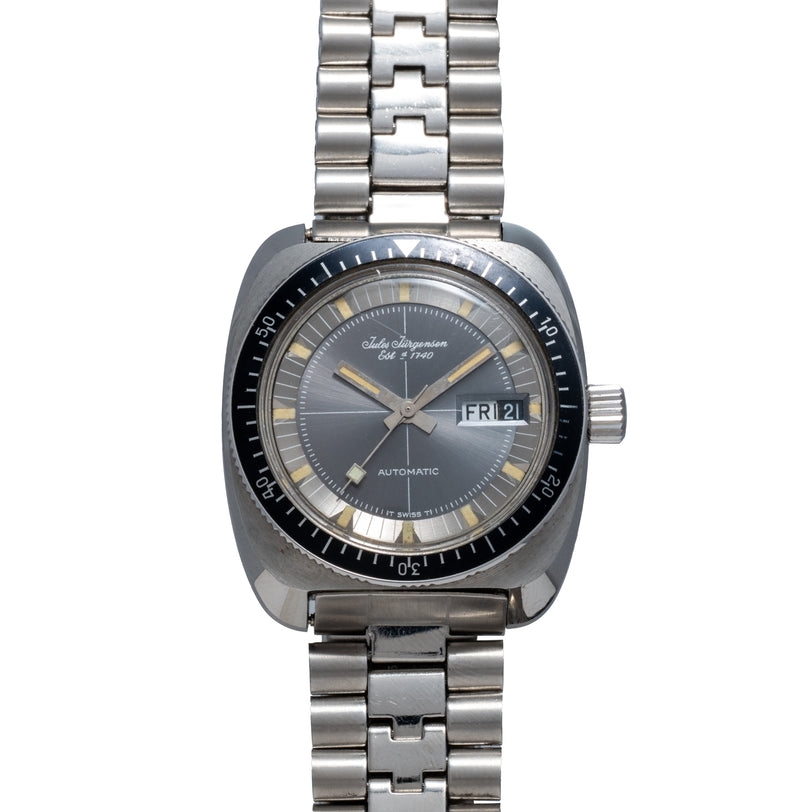 Steel dive watch with black dial, day-date window, rotating bezel, and matching steel bracelet.