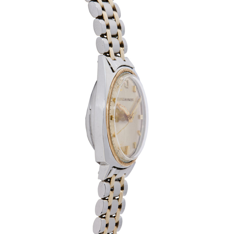 Bulova Accutron watch with oval two-tone case, cream dial, and linked bracelet with alternating silver and gold segments.