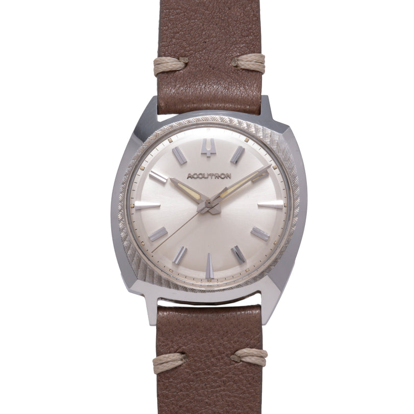 Bulova Accutron watch with silver-tone tonneau case, silver dial, baton hour markers, and brown leather strap with tan stitch
