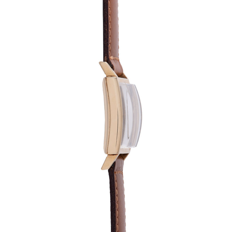 Gold-tone watch case with white dial and brown leather strap, shown from the side.