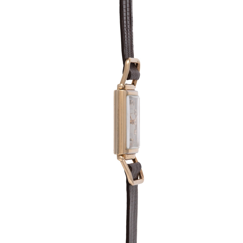 Gold-tone rectangular watch with black leather strap and metal lugs.