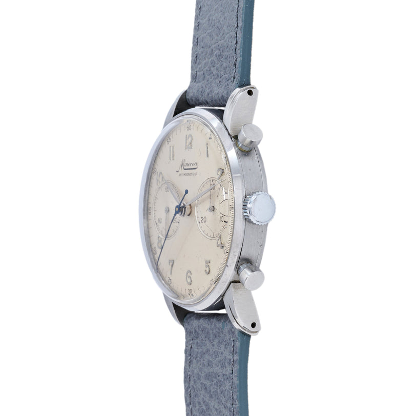 Silver-tone chronograph watch with cream dial, Arabic numerals, blue hands, and gray leather strap.