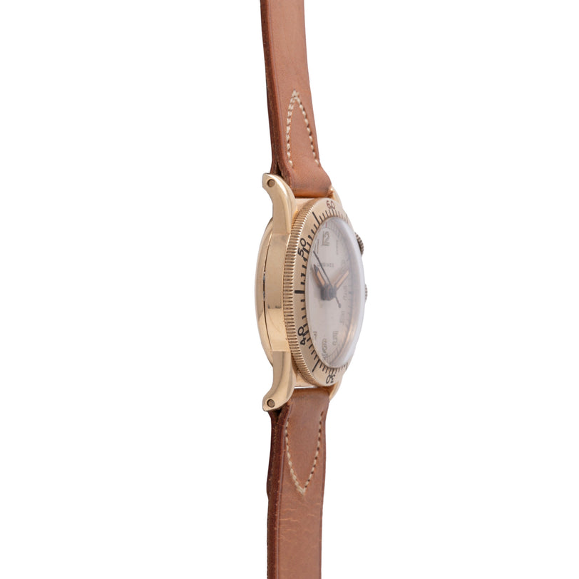 Longines Weems watch with cream dial and textured bezel on tan leather strap with stitching detail.