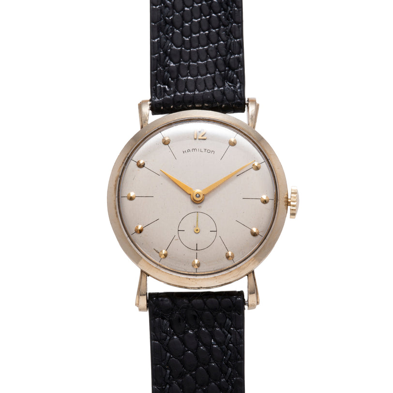 Hamilton Bradford wristwatch with silver dial, gold-tone hands and markers, subdial at 6 o'clock, and black leather strap.