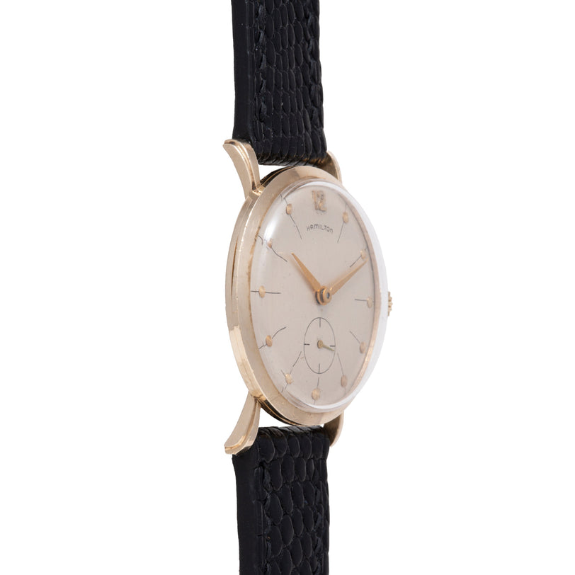 Gold-tone Hamilton watch with cream dial, gold hour markers, and black textured leather strap.