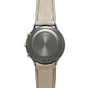 Titanium chronograph watch with gray dial, gold pushers, and beige leather strap with contrast stitching.