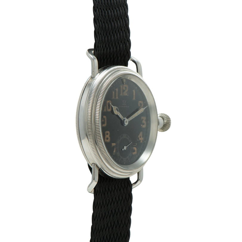 Silver-toned watch with dark dial, Arabic numerals, and black fabric strap.