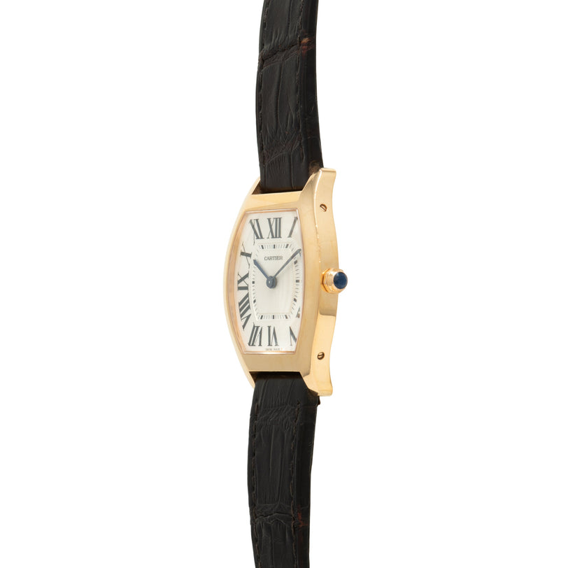 Gold-tone rectangular watch with cream dial, Roman numerals, black leather strap, and crown with dark stone.