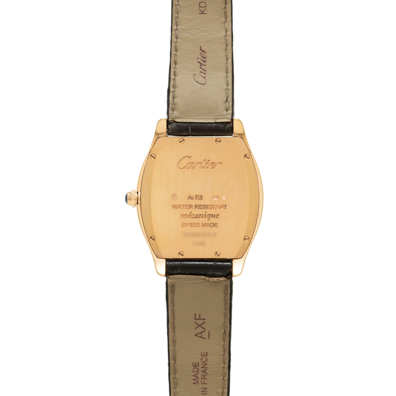 Cartier Tortue watch with gold-tone tonneau case, engraved back, and dark leather strap.