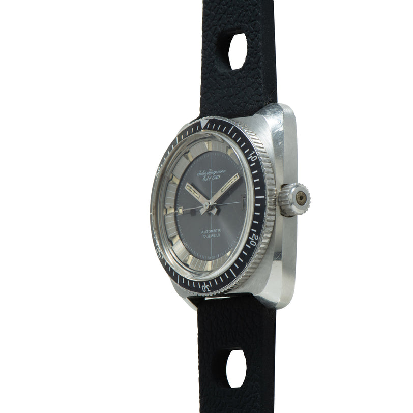 Jules Jurgensen Diver automatic watch with dark dial, rotating bezel, and black rubber strap with oval cutouts.