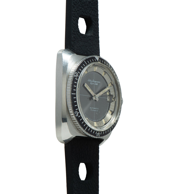 Jules Jurgensen Diver watch with charcoal dial, rotating bezel, date window, and black fabric strap.