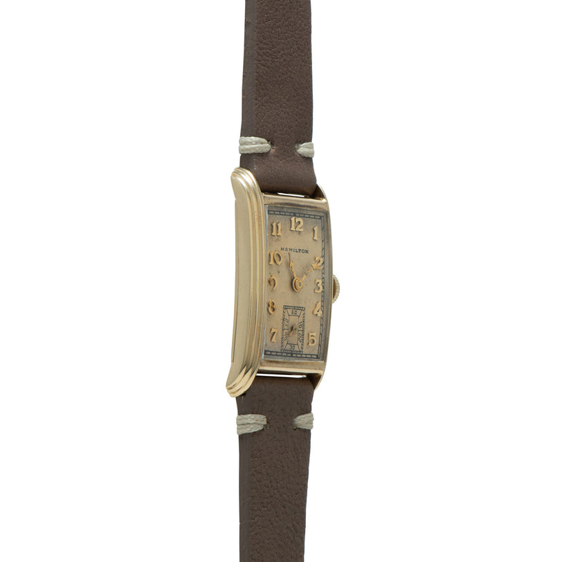 Hamilton Sherwood rectangular watch with cream dial, gold-tone case, and brown leather strap.