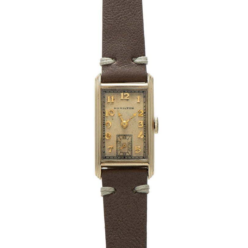 Hamilton Sherwood rectangular watch with cream dial, Arabic numerals, and brown leather strap.