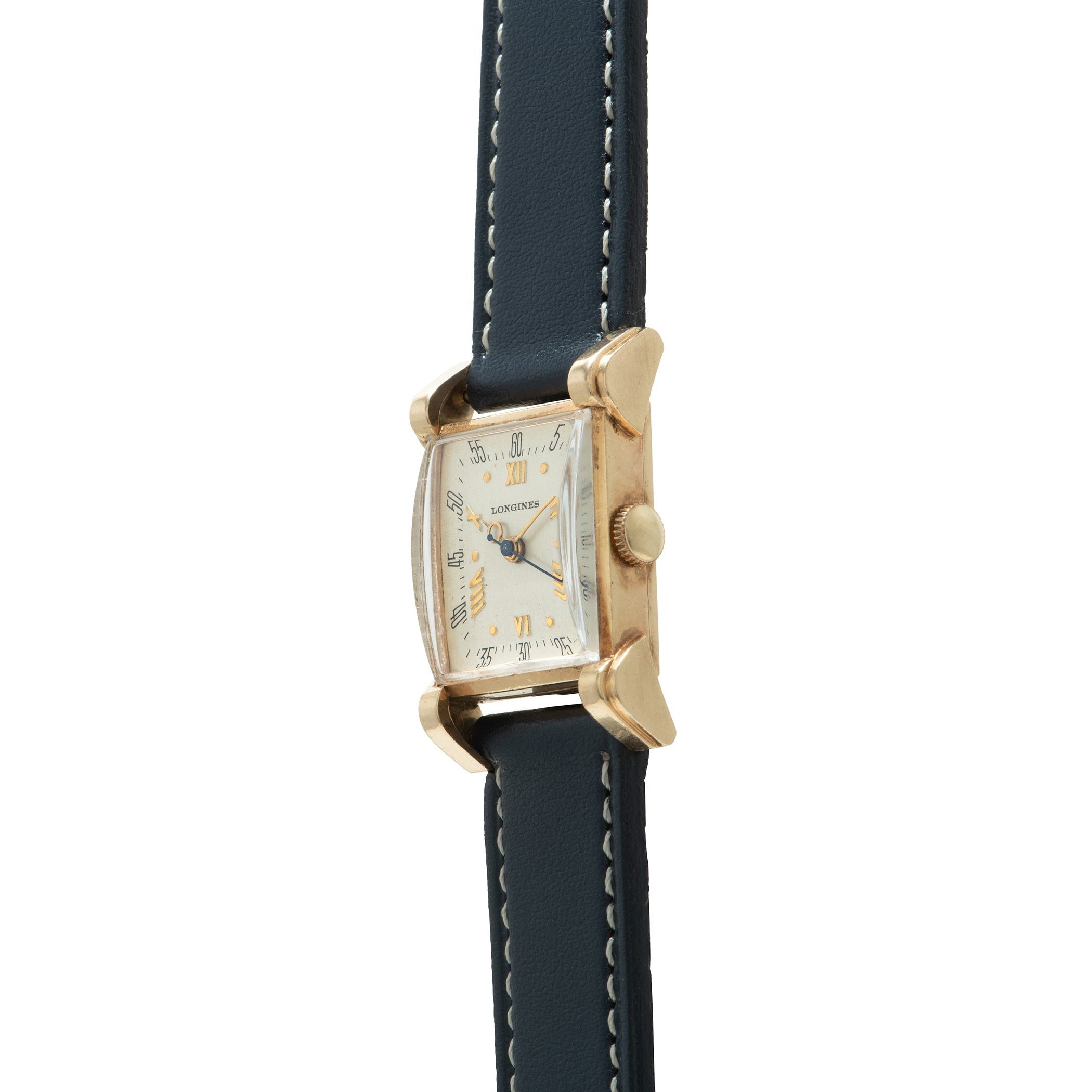 Longines rectangular watch with cream dial, gold-tone case, hooded lugs, and dark blue leather strap with white stitching.
