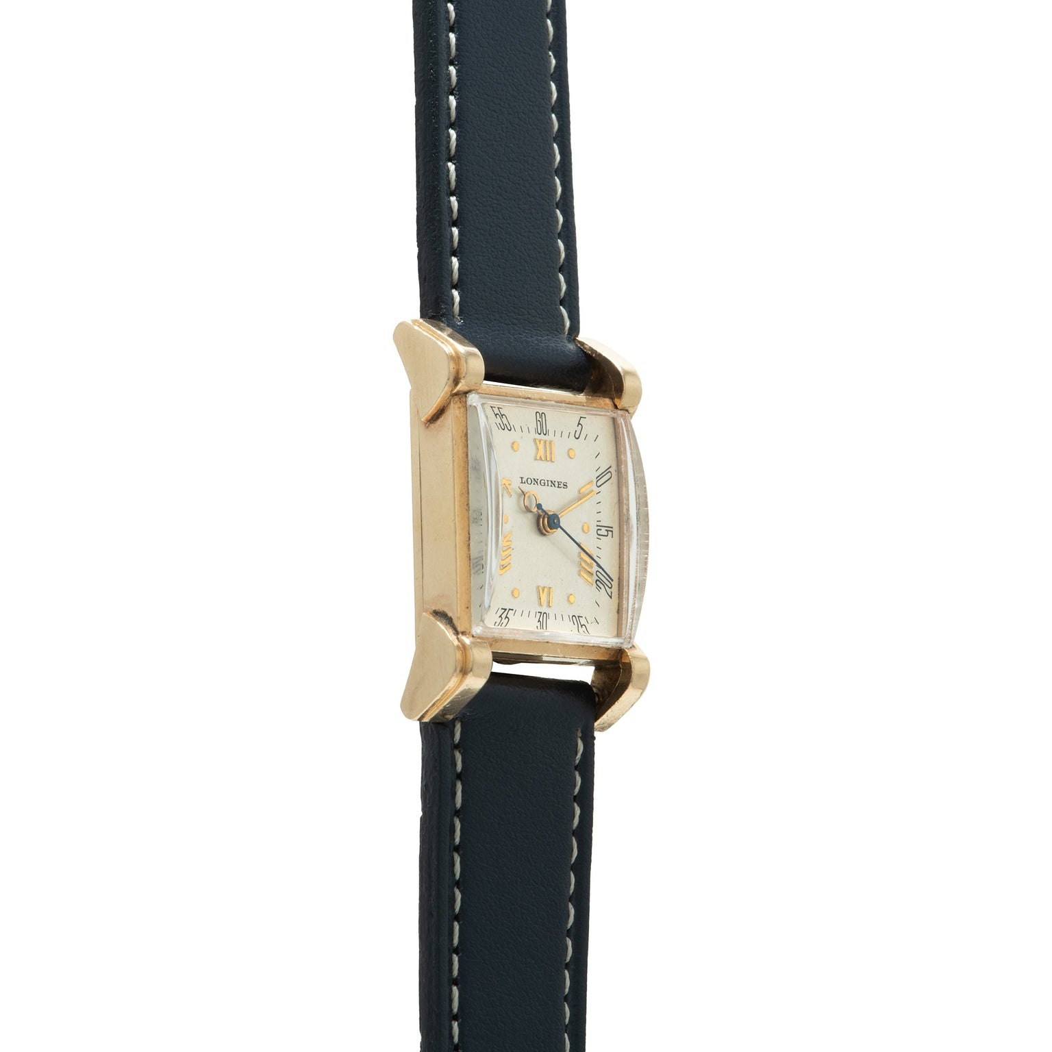 Longines Tank watch with rectangular cream dial, Roman numerals, gold-tone case with hooded lugs, and dark leather strap with
