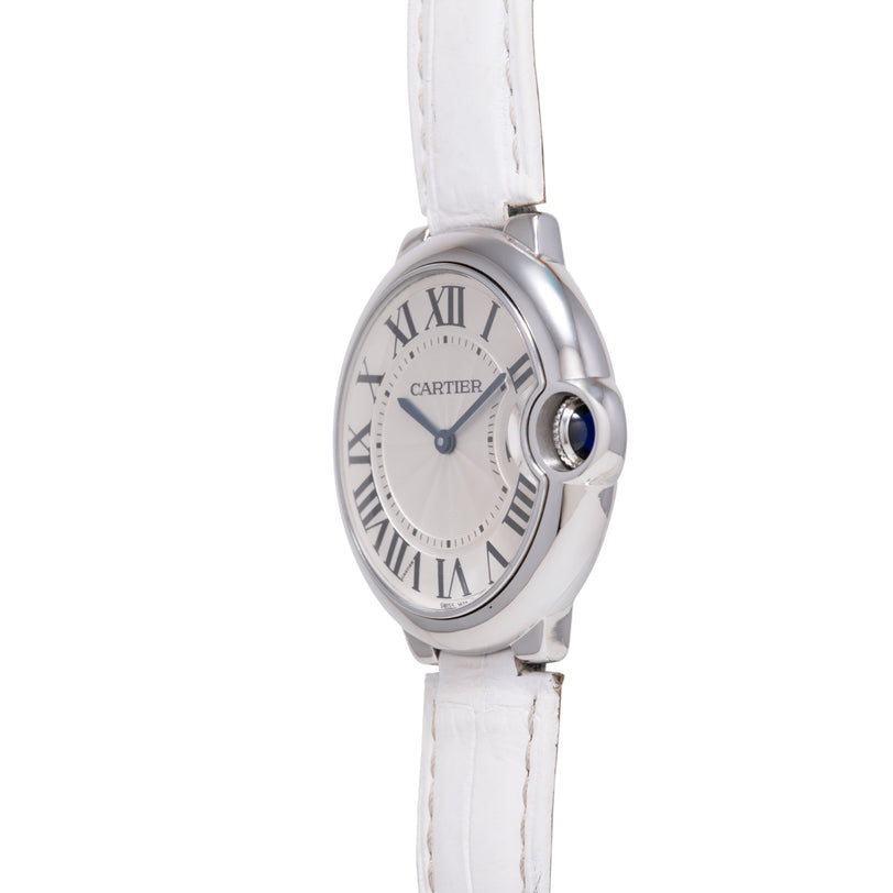 Cartier Ballon Bleu watch with silver case, white dial featuring Roman numerals, blue sapphire crown, and white leather strap