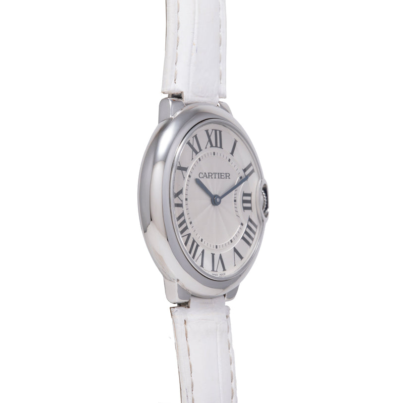 Silver-toned Cartier Ballon Bleu watch with white leather strap and Roman numeral dial.