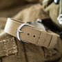Elgin USMC watch with tan canvas strap and silver buckle displayed on khaki fabric.