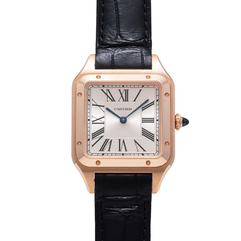 Rose gold square watch with white dial, Roman numerals, blue hands, black leather strap, and crown with black gemstone.