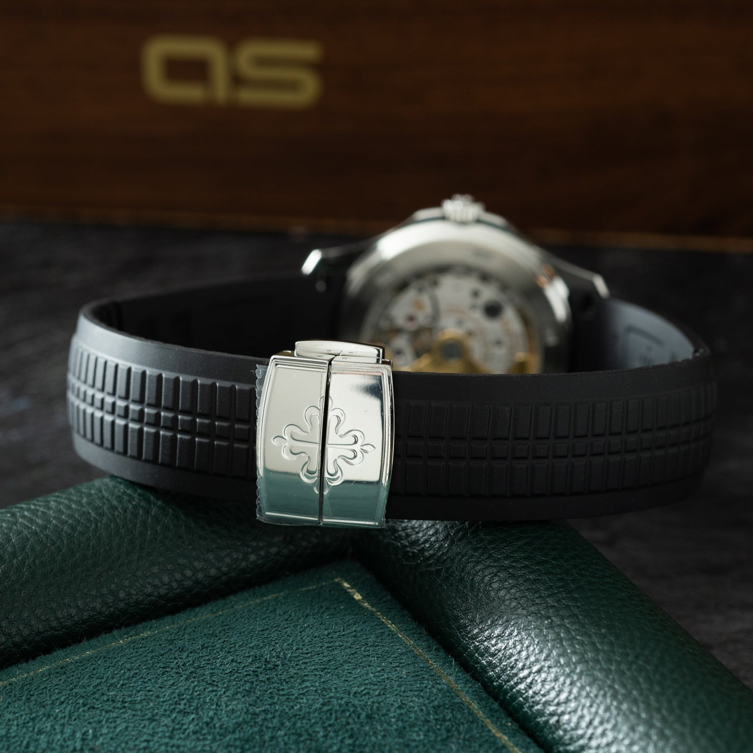 Patek Philippe Aquanaut watch with black rubber strap and cushioned steel case displaying cross motif on clasp.