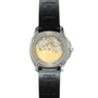 Steel watch with black rubber strap showing exposed golden movement and cross emblem on caseback.