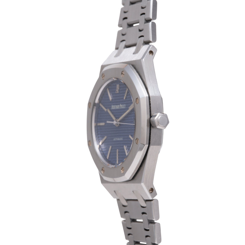 Stainless steel watch with octagonal case, deep blue dial, and matching metal bracelet shown from side angle.