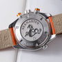 Stainless steel chronograph watch with orange and beige leather strap, showing caseback with seahorse emblem and 600m depth r