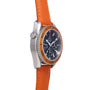 Stainless steel watch with dark blue chronograph dial, orange rubber bezel, and orange leather strap.
