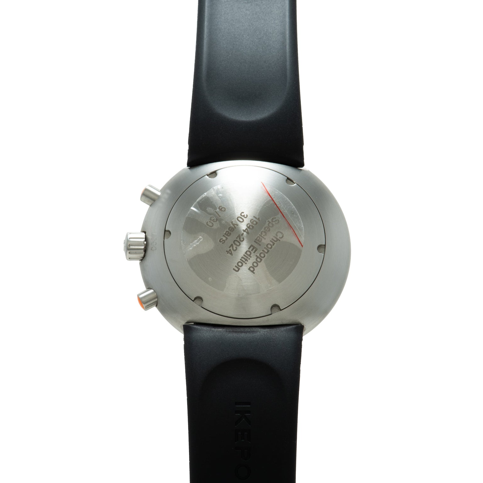 Stainless steel chronograph watch with black rubber strap, viewed from the case back showing engraved text and red chronograp